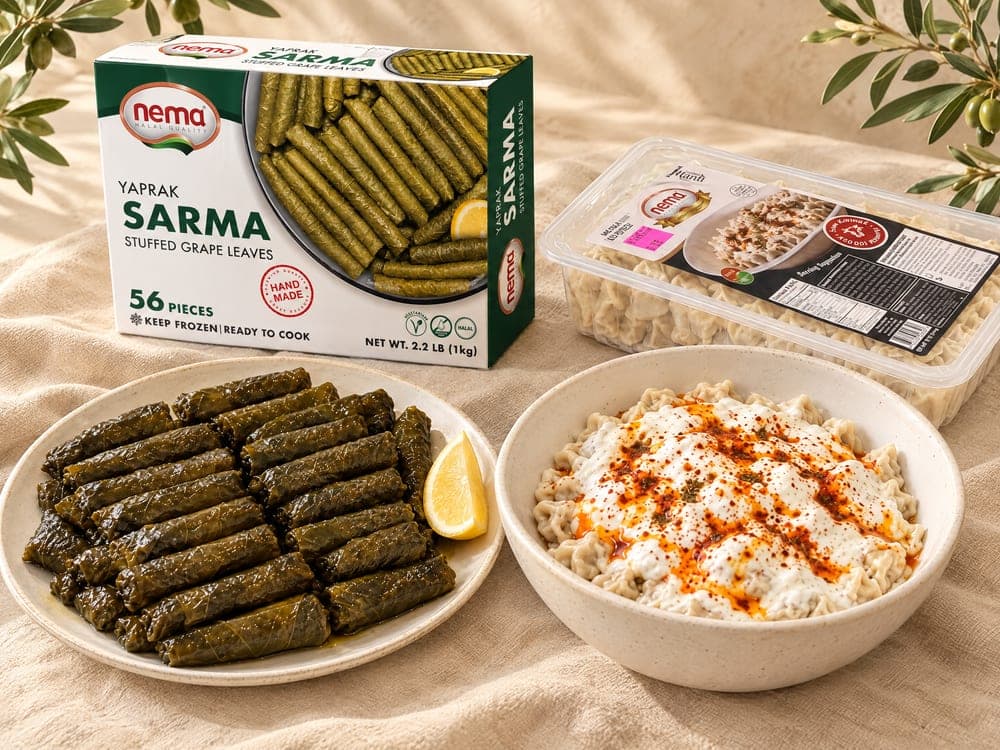 علبة ورق عنب محشي من Nema وصينية مانتي من Nema خلف طبق من ورق العنب المحشي ووعاء مانتي مع الزبادي بالثوم